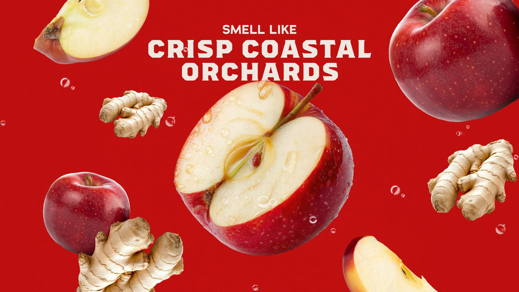 'SMELL LIKE CRISP COASTAL ORCHIDS' above floating red apples and ginger roots on a solid red background to showcase the ingredients for Oceanside Orchard