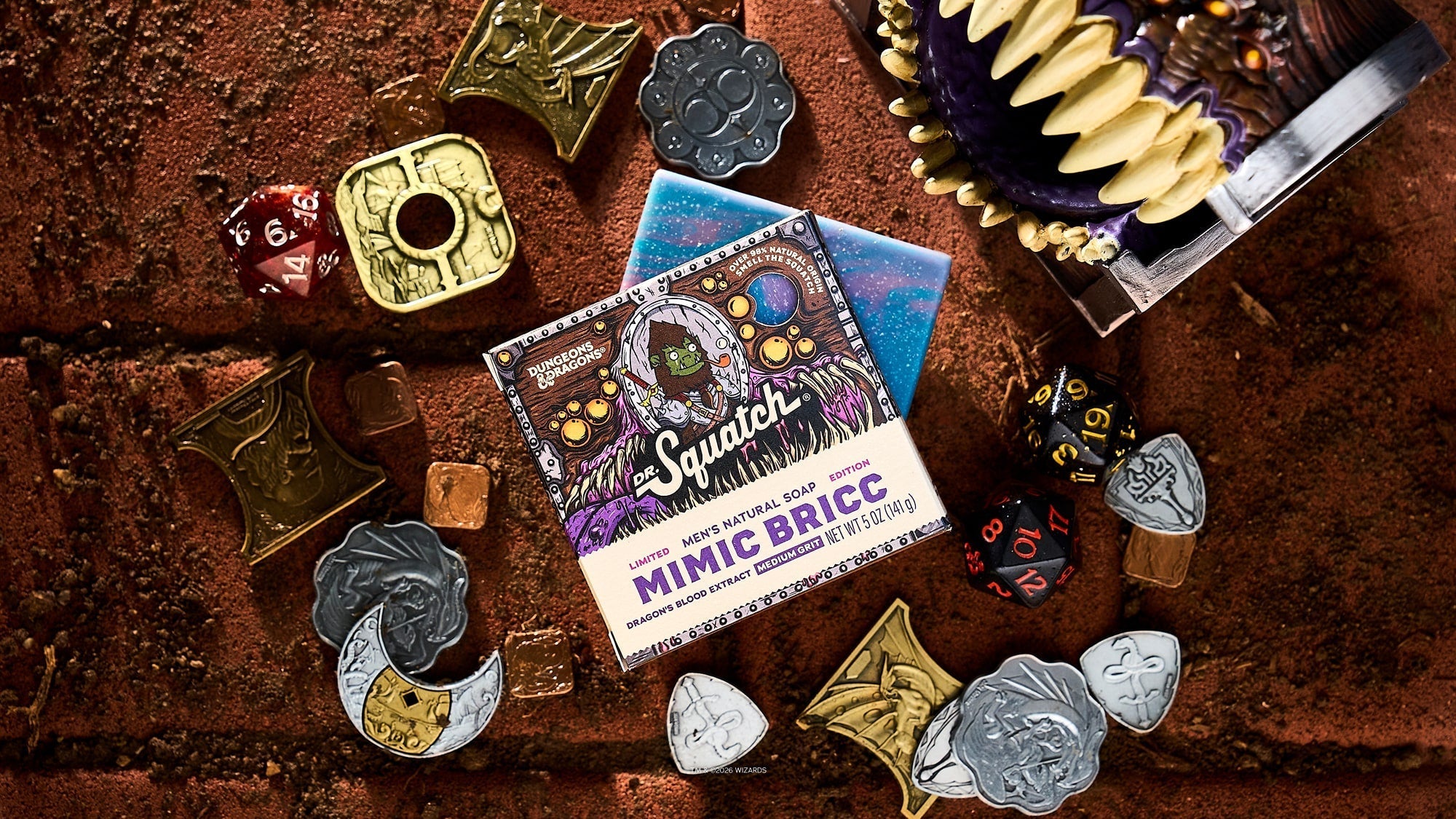 Mimic Bricc bar soap package surrounded by Dungeons & Dragons dice, metal miniature charms, and a starry blue pouch on brown textured surface.